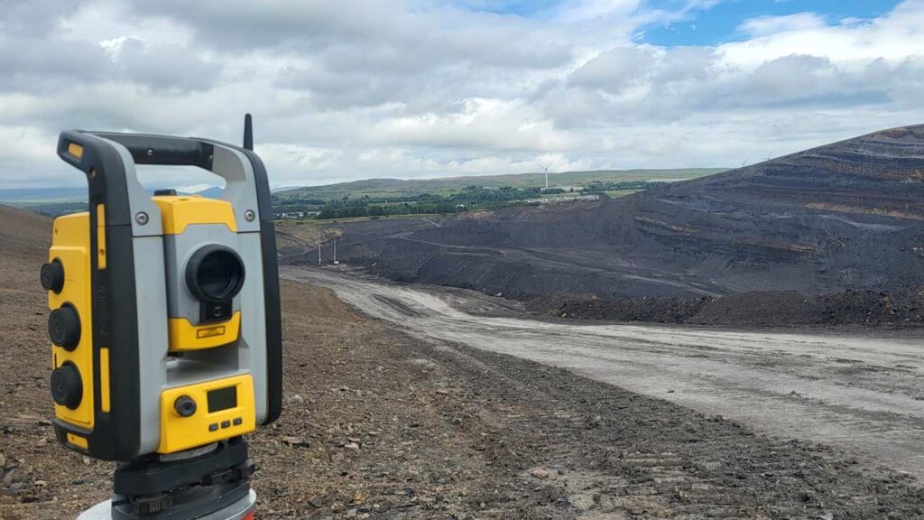 Land surveyor using a total station for setting out and levelling works